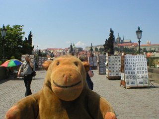 Mr Monkey looking at artists stands on the Charles Bridge