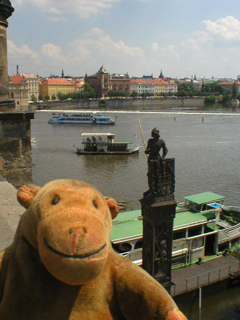 Mr Monkey looking down at the statue of Bruncvík beside the Charles Bridge