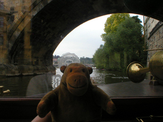 Mr Monkey looking through an arch of Charles Bridge