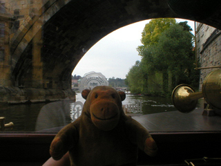 Mr Monkey looking through an arch of Charles Bridge