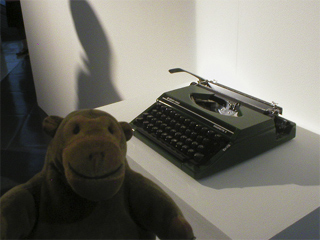 Mr Monkey looking at one of the typewriters used to play Repetition