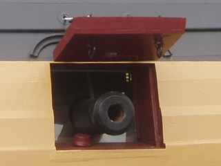 The mouth of a cannon pointing through a gunport on HMS Victory
