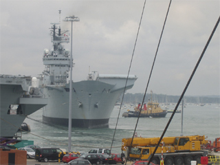 HMS Illustrious being turned around by tugs