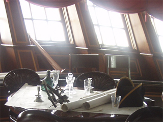 The captain's bicorne on the table in the captain's cabin