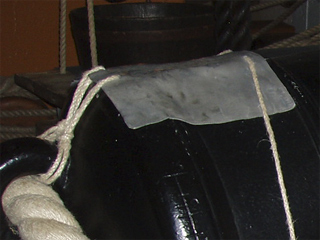 A lead apron over the vent of a 32 pounder gun