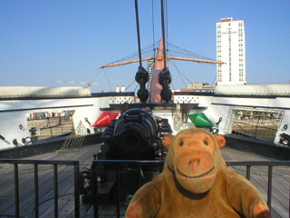 Mr Monkey looking at the bow chaser aboard HMS Warrior
