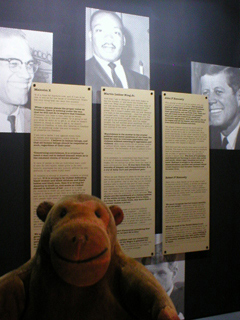Mr Monkey reading a panel about assassinated American leaders