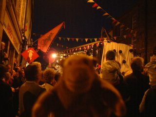 Mr Monkey in a crowd with a float in the background