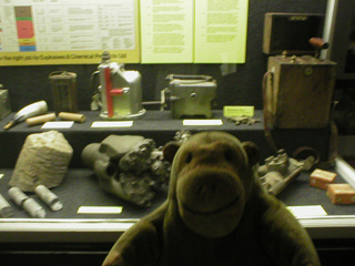 Mr Monkey looking at a display of mining equipment