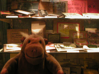 Mr Monkey examining a collection of photographic paper packages