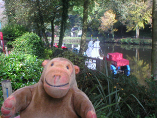 Mr Monkey looking at unilluminated boats moored on the river
