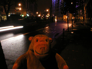 Mr Monkey walking along Kingsway at night