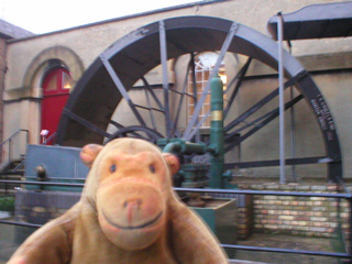 Mr Monkey looking at a waterwheel