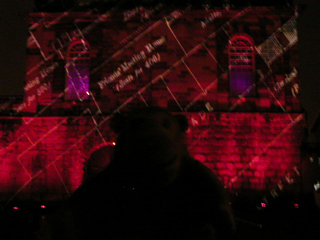 Mr Monkey watching historical maps projected onto the Sallyport Tower