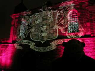 Mr Monkey looking at the arms of Newcastle projected onto the Sallyport Tower