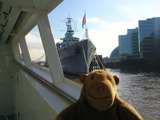 Mr Monkey looking up at HMS Belfast from the river