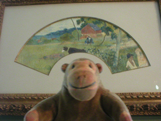 Mr Monkey looking at a fan painted by Gauguin