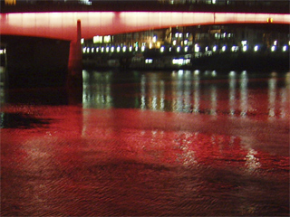 The Thames coloured red by lights on London Bridge