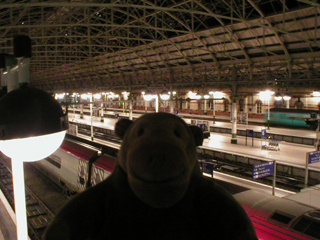 Mr Monkey looking down from the bridge at Piccadilly Station