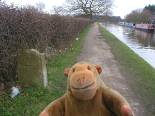 Mr Monkey looking at the milestone at Wood Lanes
