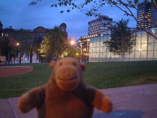 Mr Monkey with park and a glass building behind him
