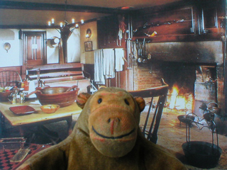 Mr Monkey in front of a picture of the recreation of Conkey's Tavern