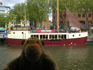 Mr Monkey looking at the Ferry Station from across the harbour