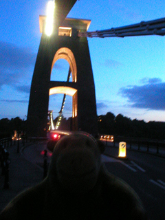 Mr Monkey approaching the illuminated suspension bridge