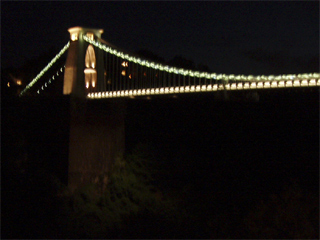 The western end of the suspension bridge illuminated at night