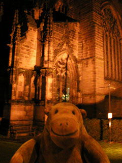 Mr Monkey looking at the floodlit front of Chester Cathedral