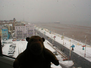 Mr Monkey looking out of the hotel window at a snowy Blackpool