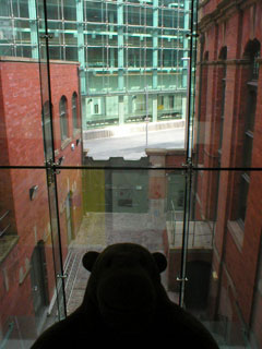 Mr Monkey looking down into the old courtyard from the connecting bridge