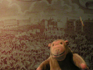 Mr Monkey looking at a large copy of a print showing the Peterloo massacre