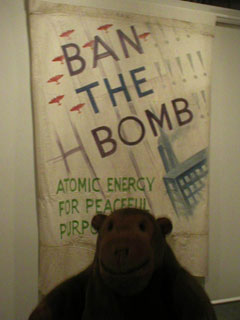 Mr Monkey looking at a Ban The Bomb banner