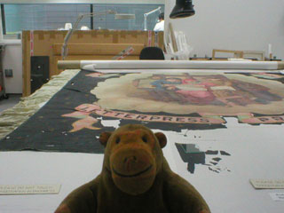 Mr Monkey examining a banner under conservation