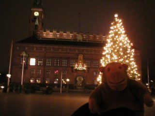 Mr Monkey in front of the lit up Christmas tree