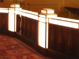 The carved pillars and changing lights of the orchestra balustrade