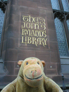 Mr Monkey in front of the carved John Rylands Library sign