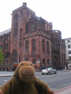 Mr Monkey looking at the John Rylands Library from across Deansgate