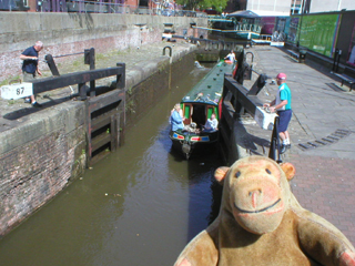 Mr Monkey watching the narrowboat set off through the open gates of Lock 87