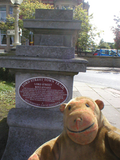 Mr Monkey looking at the Lord Street Boulevard red plaque