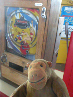 Mr Monkey looking at a bagetelle machine