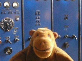 Mr Monkey in front of a power station control panel