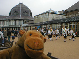 Mr Monkey watching morris men outside the Buxton Pavilion