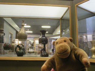 Mr Monkey in front of a case of pottery