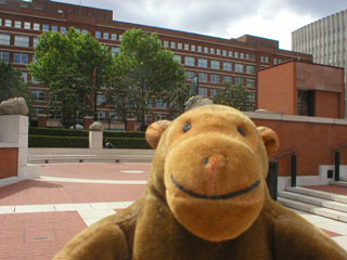 Mr Monkey in the piazza, with Gormley's Planets behind him outside the British Library