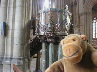Mr Monkey examining a pulpit made of copper and marble