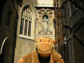 Mr Monkey in front of a statue of Elizabeth I