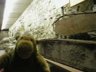 Mr Monkey beside an iron coffin in the crypt