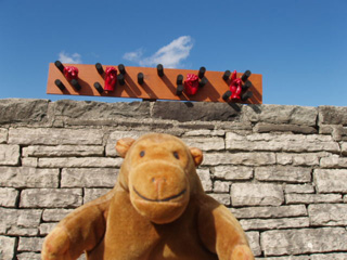 Mr Monkey in front of a braille and sign language artwork on a rampart